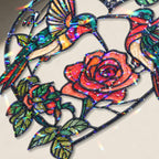 Close-up of two hummingbirds and red rose heart holographic acrylic suncatcher showing broken glass rainbow finish.

