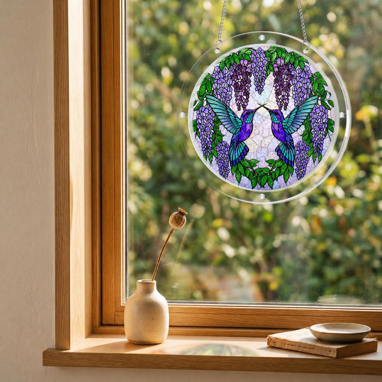 Wisteria hummingbird acrylic puzzle suncatcher hanging by a bright balcony window in natural sunlight.